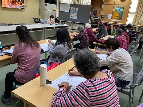 長者在歌唱課中全神貫注聆聽、做筆記。圖／里長徐福進提供
