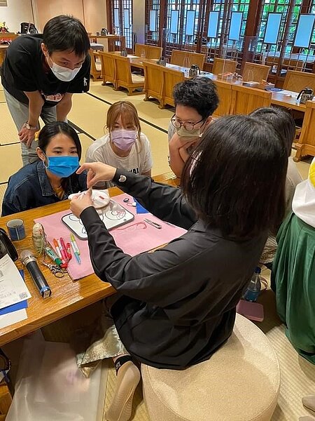 一針一線刺進山茶花圖案中。圖／易小滿攝