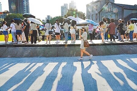 
中央氣象局22日發布18縣市高溫燈號，雙北及宜蘭、花蓮氣溫突破38℃，卓溪、玉里超過41℃，其他地區也高達37℃以上。台北22日艷陽高照，參加華山1914文化創意產業園區商業展演活動的民眾，紛紛撐傘遮陽。（黃子明攝）
