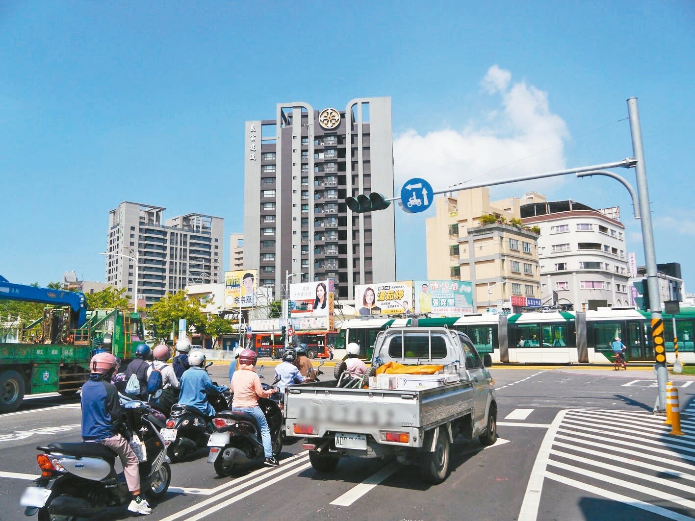 高雄天氣酷熱,凱旋路是輕軌行車路線,機車騎士在橫向交會大路口常停等90秒、等輕軌列車通過,但綠燈通行時間僅20秒。記者徐白櫻/攝影