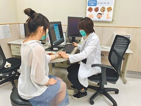 中醫師周書玉(右)透過診斷,協助患者改善失眠問題。(莊旻靜攝)