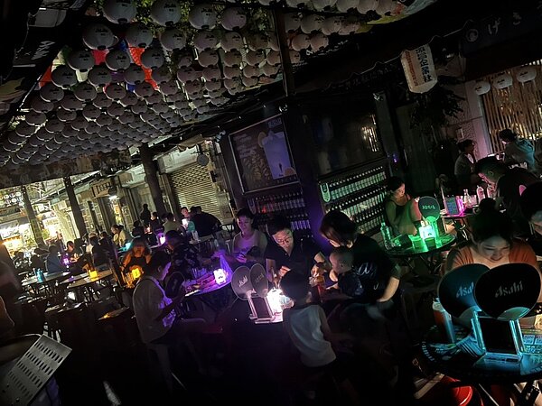 24日晚消費者在逢甲夜市串燒店用餐,吃到一半燈突然全黑,詢問才知道是停電。圖/業者提供