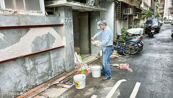 泥作師傅處理牆面，讓新水泥密切的砌合。