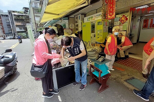 文山區萬隆里林宗弘里長與里民志工協助里民資源回收兌換物資。圖/擷取自臺北市鄰里服務網