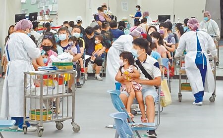 台北市提供「6個月以上至5歲」兒童莫德納疫苗接種，家長們30日踴躍帶著幼兒前往台北田徑場的疫苗注射站施打。（姚志平攝）