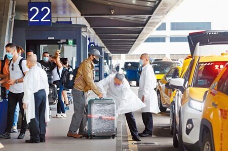 指揮中心專家諮詢小組召集人張上淳昨表示,口罩政策還是要看疫情控制的程度,逐步放寬。圖為在桃園機場第一航廈外,剛入境的旅客正在排隊搭乘防疫計程車。(范揚光攝)