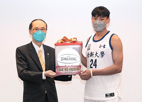 永慶房屋致贈印有「世不可擋 永奪冠軍」字樣的紀念籃球,由隊長簡賀宇代表接受。圖/永慶房產集團提供