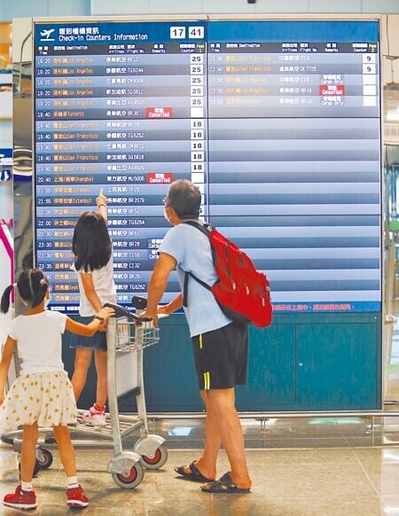 解放軍4日中午起在台灣周邊海域軍演,我交通部已協調航班改道。圖為到桃園機場搭機旅客在觀看飛航資訊表。(陳麒全攝)