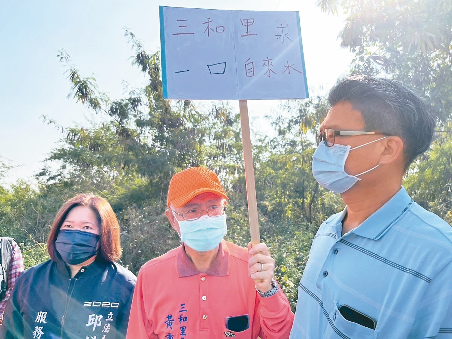 大樹區三和里長黃重信（中）昨至大泉淨水場舉牌陳情，爭取自來水延管工程。記者林巧璉／攝影 