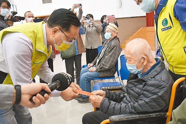 彰化市長林世賢(左)親自發放紅包給高齡102歲的人瑞林文漢。(彰化市公所提供)