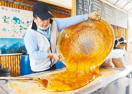 許銘委是阿里山鄉豐山村當地少數每年仍堅持循古法手工製作黑糖的村民,甘蔗原汁需經大火熬煮3、4個小時,過程中要不斷攪拌,十分耗時耗力。(呂妍庭攝)