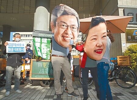 
多個環保團體昨日前往經濟部，高舉行政院長陳建仁、經濟部長王美花的頭像，抗議「綠能進度落後」、「用電大戶條款建言不予理會」等問題。（陳君瑋攝）
