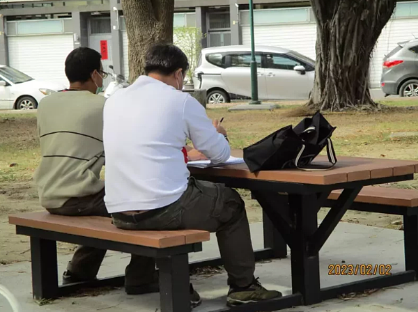 暖心書記官(右)昨天親赴邱男工地現場旁,在戶外製作詢問筆錄,協助他書寫分期筆錄,並匯款繳納第一期分期款5千元。圖/讀者提供