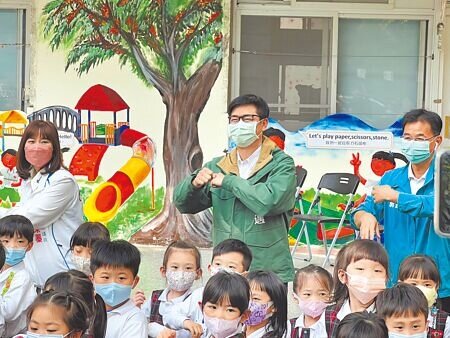 高雄市長陳其邁(後方中)20日視察前金幼兒園,宣布自今年7月起高雄市公立幼兒園全面開辦延長照顧,費用每小時不超過50元,其餘經費差額均由高市府負擔,且1人即開班。(楊舒婷攝)