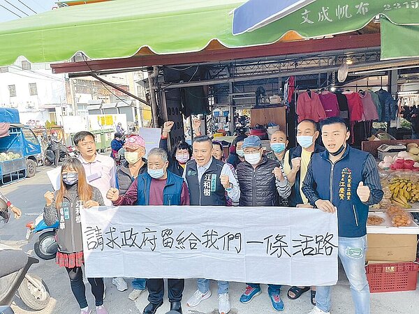 台中市議員江和樹1日到新仁市場帶著攤商拉白布條陳情。(江和樹提供/馮惠宜台中傳真)