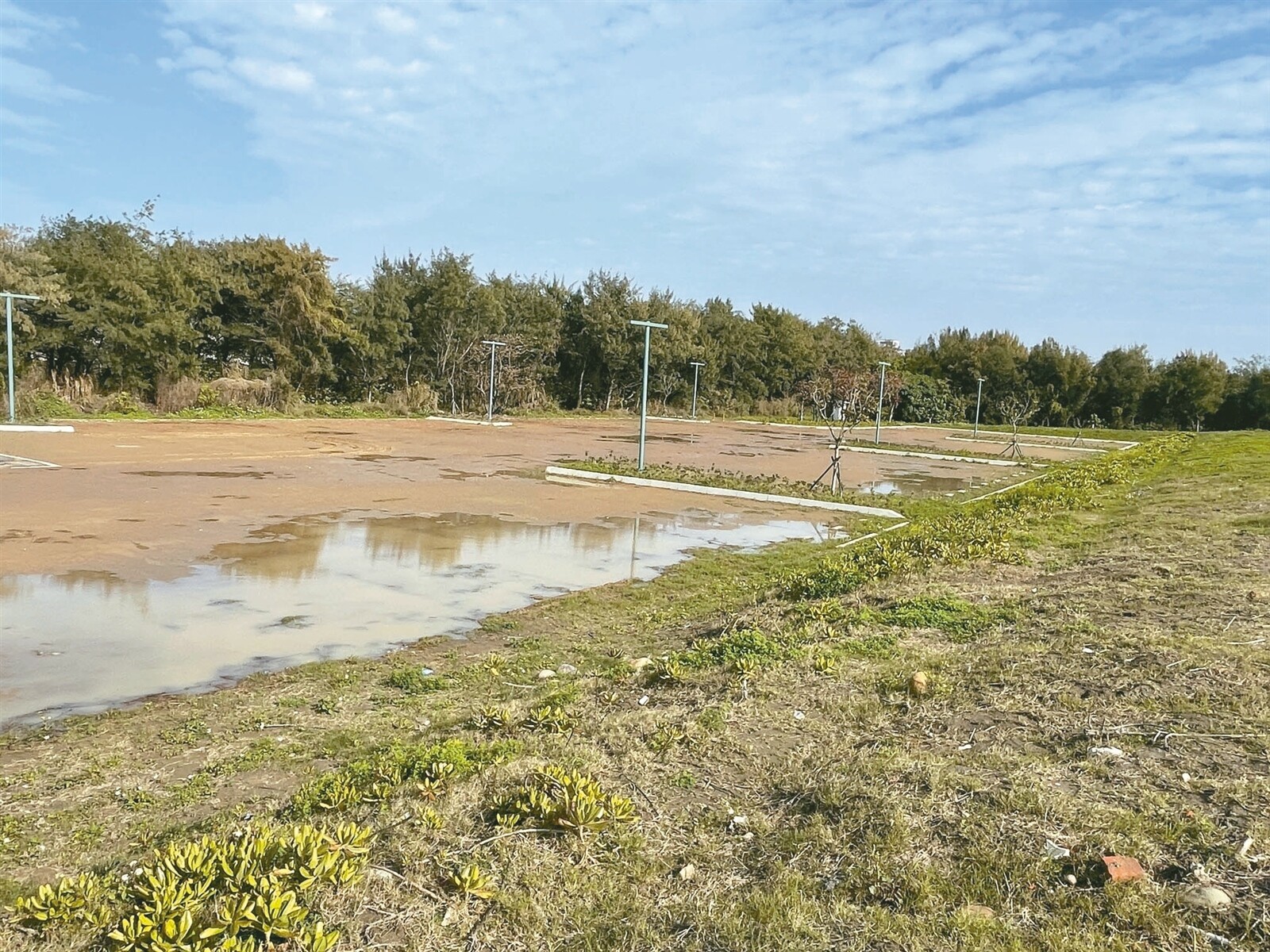 新竹南寮漁港南岸堆置淤泥與土方不斷沖刷，造成一旁新建停車場淤積。記者張裕珍／攝影 