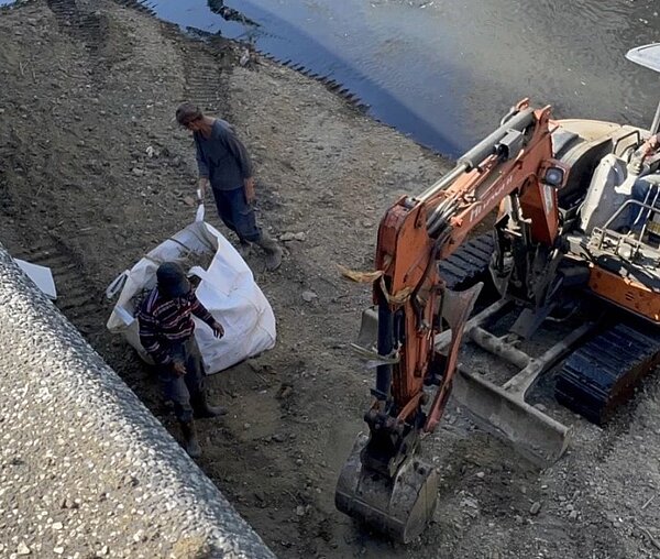 新北市新莊好市多賣場旁塔寮坑溪遭傾倒廢土及垃圾。圖/新北市環保局提供