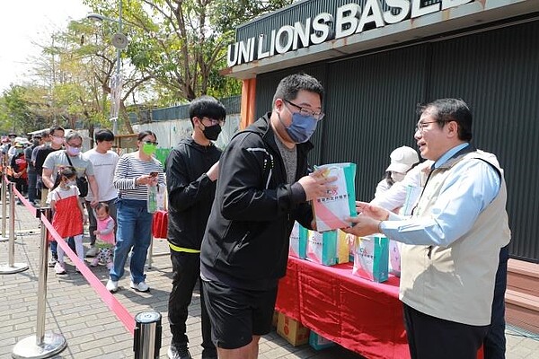 黃偉哲在台南市立棒球場前發放100份致勝大禮包。圖／南市府提供