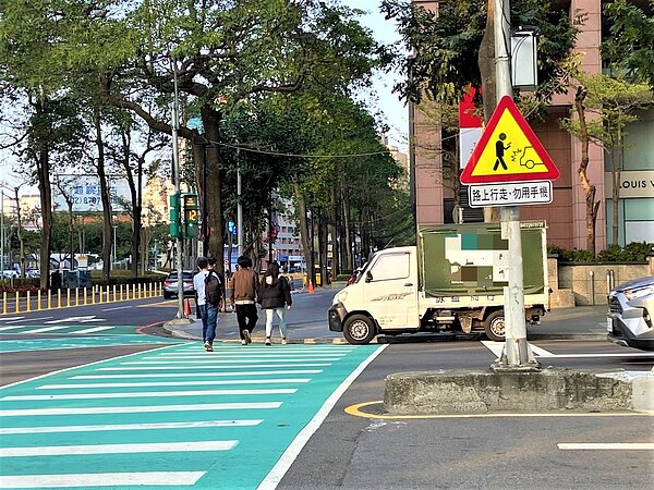 為提醒低頭族,台中市交通局在商圈、學區設置「路上行走,勿用手機」警語。圖/交通局提供