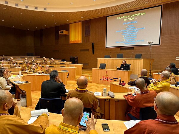 中華人間佛教聯合總會秘書長覺培法師以西班牙文說明佛光山大慈育幼院孩童創作的教宗藝術肖像畫,教宗殷殷垂詢