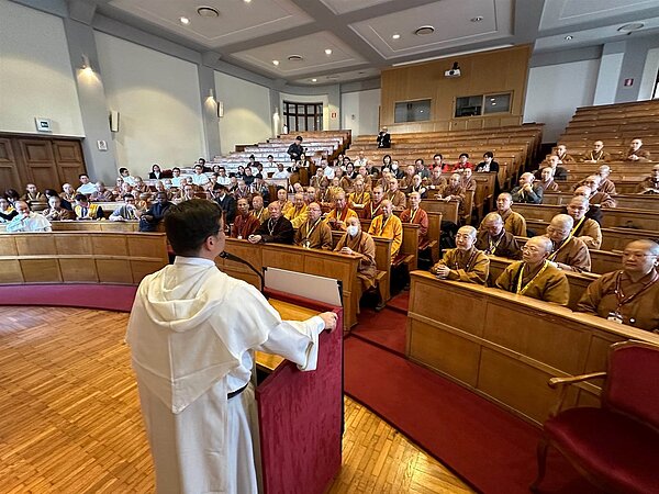 中華人間佛教聯合總會秘書長覺培法師以西班牙文說明佛光山大慈育幼院孩童創作的教宗藝術肖像畫,教宗殷殷垂詢