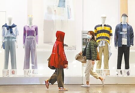 國發會27日發布2月景氣對策信號綜合判斷分數跌至10分,較1月再減1分,續創14年新低,景氣燈號則亮出第4顆代表「景氣低迷」的藍燈。圖為民眾步行經過服飾展示櫥窗。(劉宗龍攝)