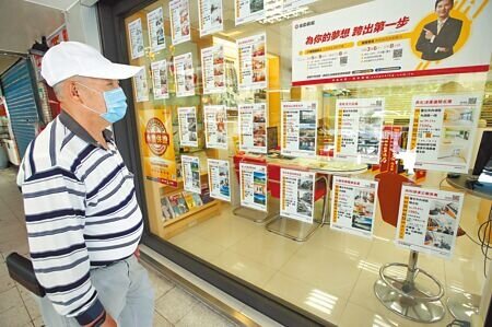 民眾觀看房仲的廣告櫥窗。(本報資料照片)