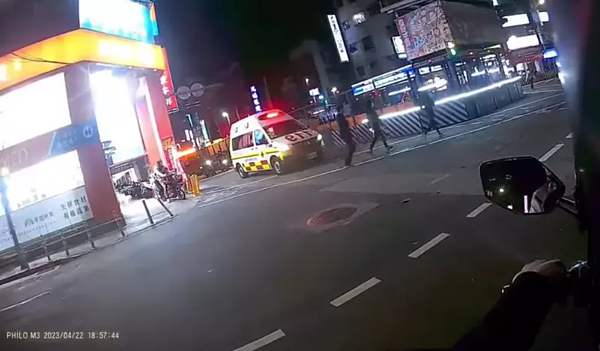 一輛台北市政府消防局救護車昨晚經過路口時完全停住,等到三名行人通過斑馬線才行駛,網友傻眼,「連救護車都得要停下來禮讓行人」。圖/取自「爆料公社」臉書社團