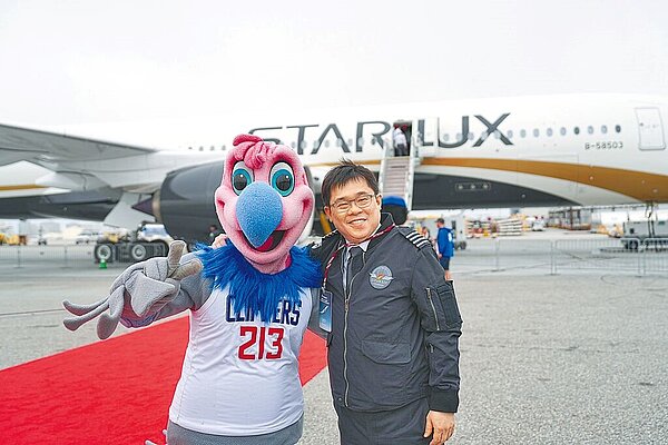 星宇航空首航台北-洛杉磯,董事長張國煒親駕抵達後,與合作夥伴NBA快艇隊吉祥物Chuck合影。(星宇航空提供)