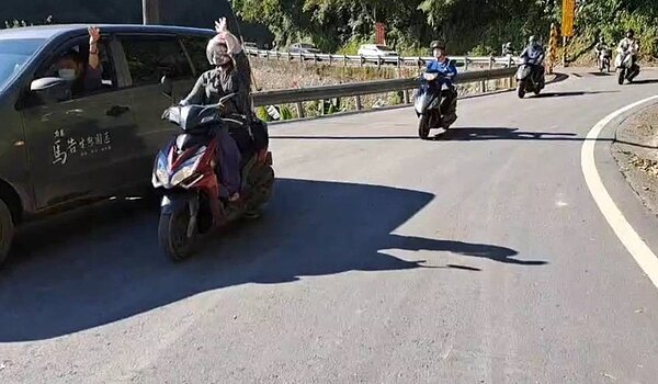 10月中的超大豪雨造成道路坍方,44輛大小車受困在明池山莊將近1個月,今天終於全數脫困,車主揮手感謝工程人員的辛苦。圖/四區工程處提供