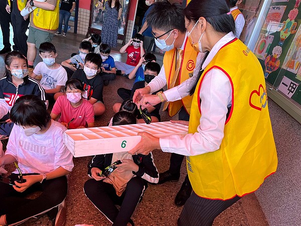 永慶不動產竹苗經管會夥伴們化身為志工，幫助小朋友戴上3D眼鏡，陪伴孩子觀看「美力台灣3D」和「台灣超人」。圖／永慶房產集團提供