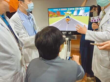 半癱婦人利用「視覺回饋」方式復健,四肢操控復健器在螢幕上打怪闖關,有趣的復健方式讓她在半年內恢復行動力。(楊舒婷攝)