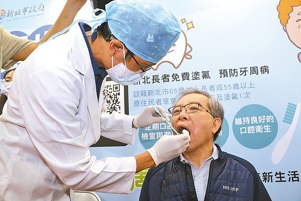 新北市牙醫師公會為市府秘書長林祐賢示範塗氟顧齒。圖/新北市社會局提供