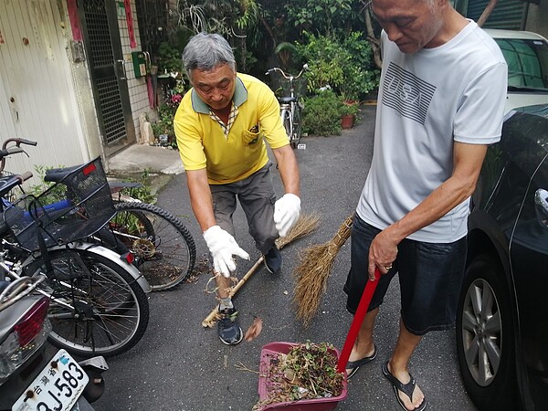 志工撿起路邊的垃圾。圖／截取自「臺北市鄰里服務網」