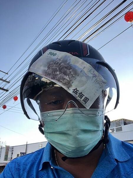 一名網友騎車環島的途中,被空中飛來的500元大鈔,給打中安全帽的護目鏡了。 圖擷自騎車環島趣