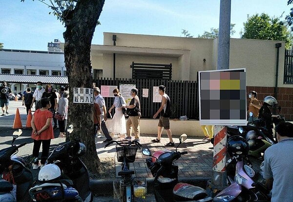 高雄市瑞豐國中校門口的交通號誌桿上,今天投票日仍懸選舉看板,引起議論。圖/讀者提供