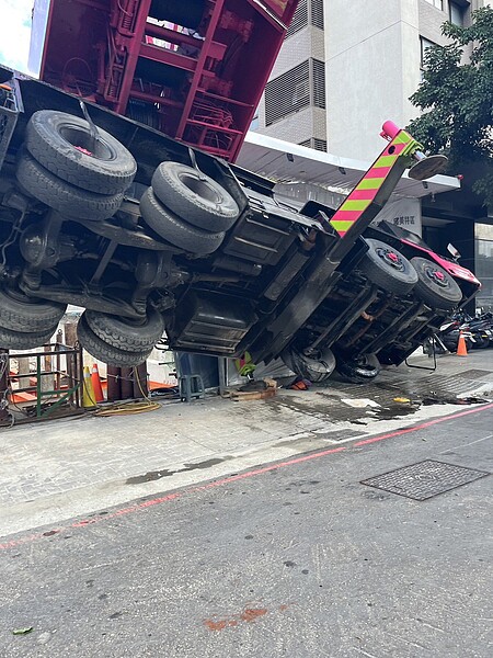 台中市西區五權西路一段的工地，今天中午傳出吊車翻覆意外，警方到場交管。圖／讀者提供
