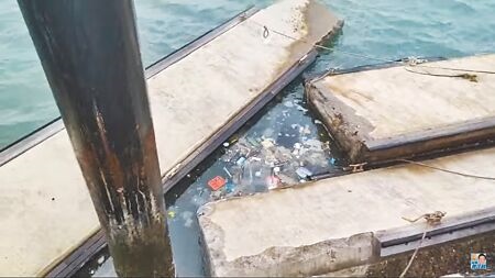 桃園市斥資2.7億在竹圍漁港新建遊艇專用碼頭，議員詹江村7日直擊浮動碼頭全損壞擠在岸邊，隨海浪載浮載沉，周遭都是垃圾。（蔡依珍攝）