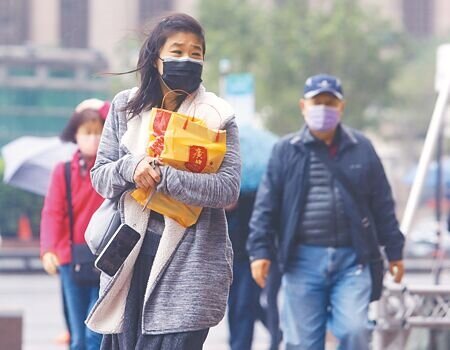 受東北季風影響,北部及東半部為陰短暫雨天氣,13日台北地區持續低溫,一名民眾穿妥保暖衣物頂著陣風外出。(陳怡誠攝)