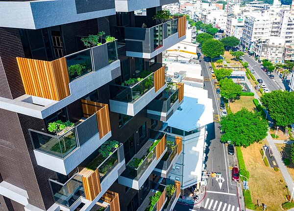 高雄市政府推「高雄厝計畫」多年,累計14萬戶申請,太陽光電總設置量超過581百萬瓩,綠化面積達100座國際標準足球場,合計每年創能減碳量達138萬公噸。圖/高市工務局提供