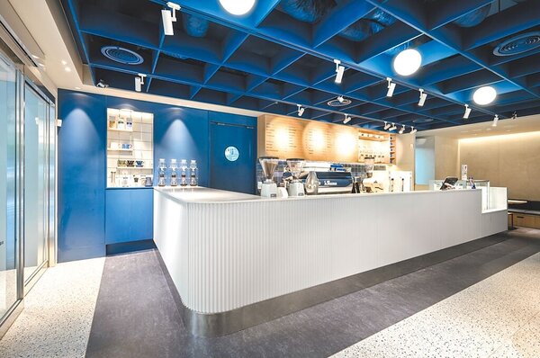 Let’s Cafe PLUS運用不同材質的藍色與淺色木紋，輔以金屬元素點綴空間呈現質感。（全家提供）