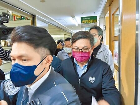 
台南市政府經發局長陳凱凌（紫色口罩者）因涉弊案遭約談，由檢調人員陪同帶到局長辦公室搜索。（洪榮志攝）
