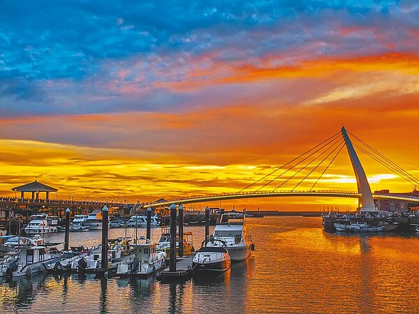 來到輕軌淡水漁人碼頭站,進入港區便可見到著名地標、全長165公尺的「情人橋」,橋身以流線的單面斜張橋橫跨港區,白色風帆造型十分搶眼,傍晚時分可一覽夕陽餘暉的美景。(淡水區公所提供/黃敬文新北傳真)