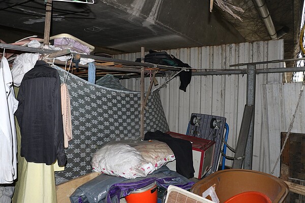 街友窩居在重新橋下與堤防間空間。圖/新北市社會局提供