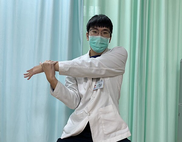 第一式「手臂交叉伸展」,坐著時,對側手抓伸展側手的腕部將手臂水平橫跨身體至對側伸展牽拉,伸展時維持10~15秒一次,可做5~10次一回合,一天做3~5回合。圖/業者提供