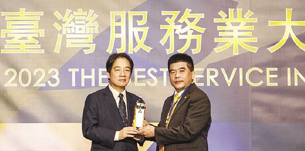 永慶房屋總經理吳良治(右)從副總統賴清德(左)手中接過2023臺灣服務業大評鑑連鎖房仲業服務金獎獎座,寫下永慶房屋11連霸的傳奇紀錄。圖/永慶提供