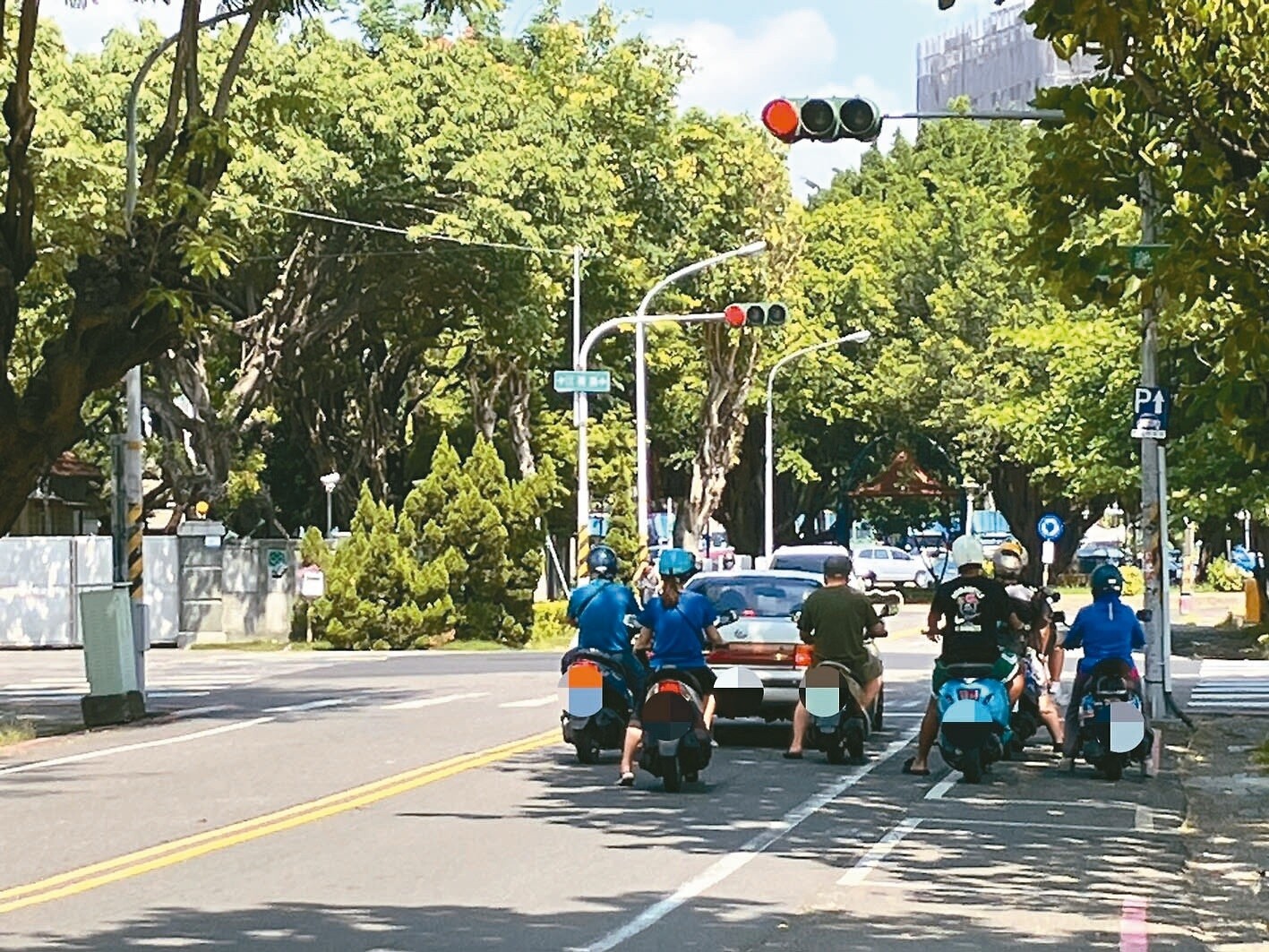 屏東縣三地門昨午測得高溫37.6度，酷暑騎車，道路陰影成停等必爭之地。記者張已亷／攝影 