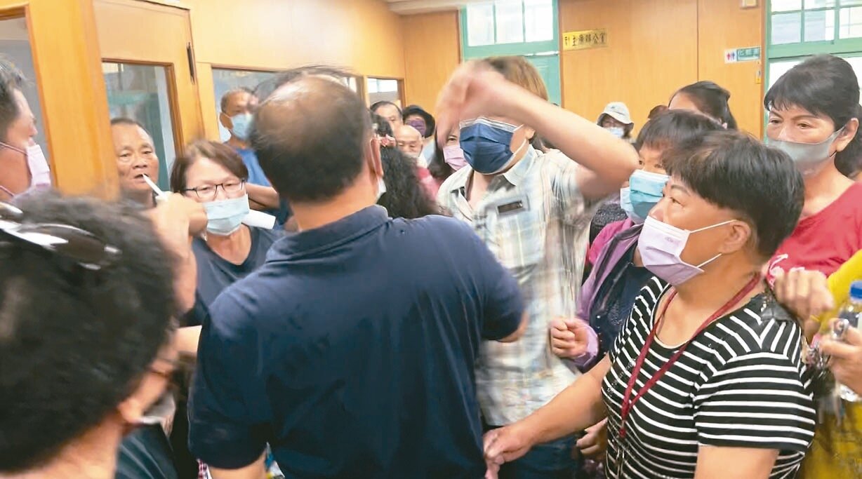 高雄大寮區公所針對垃圾掩埋場回饋金一案開會,未順利達成共識,區長黃伯雄(左藍衣者)散會要離去時被群眾包圍。記者王昭月/攝影