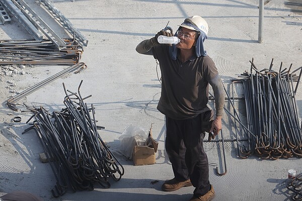 炎熱的天氣令全台許多縣市亮起「高溫警示」,中央氣象局連日發布高溫資訊,民眾需注意高溫所產生的「熱傷害」,在工地辛勤作業的勞工朋友,不時補充水分對抗熱浪。示意圖/報系資料照