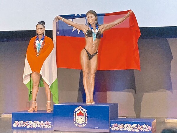 第20屆世界警察消防運動會在加拿大舉行,台灣代表團勇奪3金4銀。圖為台北市警察局王令樺(中)在女子健美健體及比基尼項目摘雙金,披掛國旗領獎。(警政署提供)